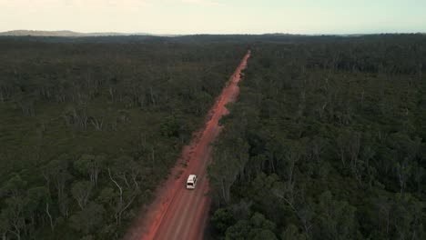 Disparo-De-Un-Dron-Orbitando-Alrededor-De-Una-Furgoneta-Blanca-Conduciendo-Por-Un-Camino-De-Tierra-Roja-De-Australia-A-Través-Del-Monte-Australiano-En-Australia-Occidental