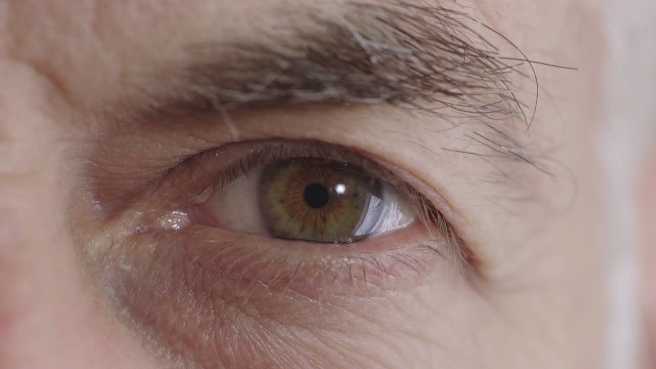 hombre maduro de cerca abriendo los ojos mirando a la cámara el iris detalle macro