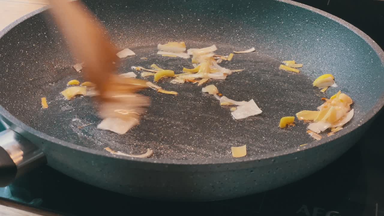 Detalje af løg og porre på pande til sund aftensmad.
