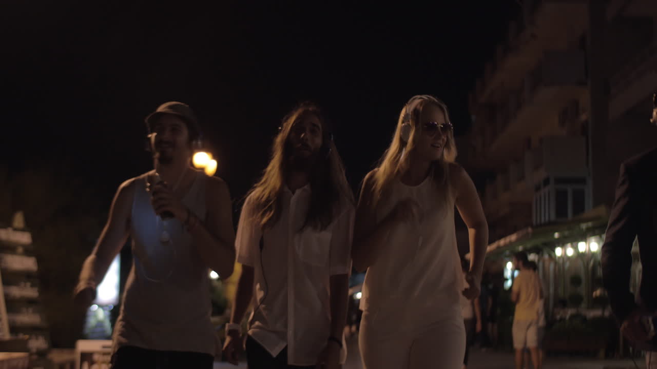 jóvenes bailando con música en la ciudad nocturna