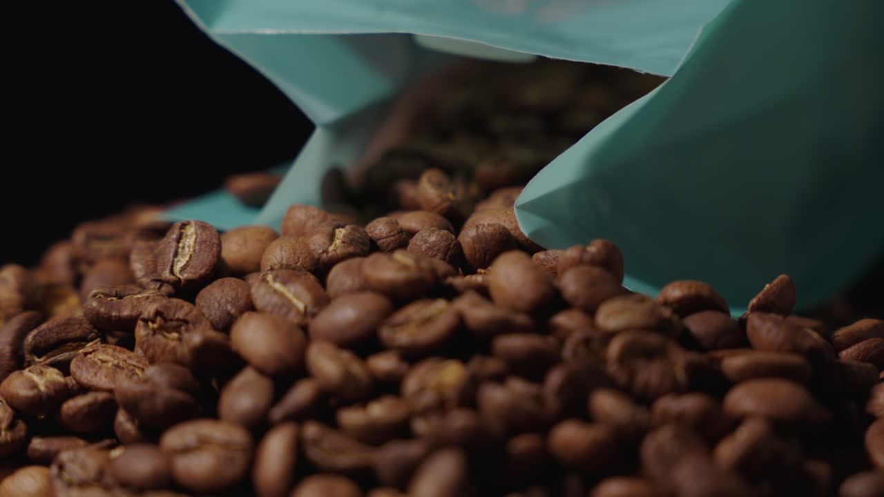 Inquadratura ravvicinata su una busta di chicchi di caffè rovesciati.