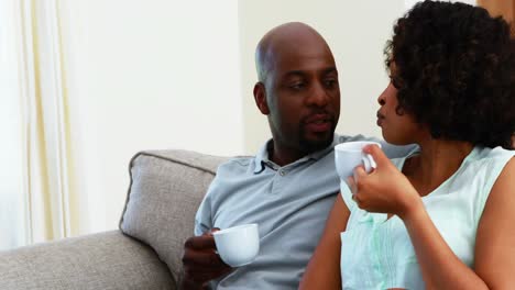 Couple-interacting-with-each-other-while-having-coffee-in-living-room-4k