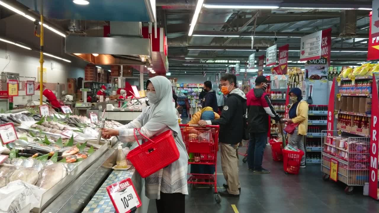 People with face mask buying groceries in the supermarket during virus pandemic.