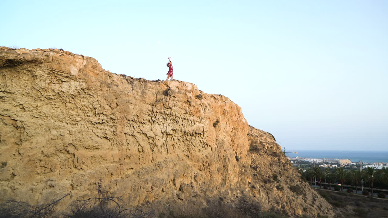 mujer en un acantilado con vistas al océano