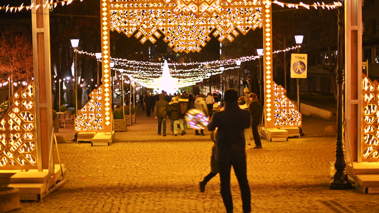 Chisinau, Moldova - December 20, 2021: People moving through the Christmas Market at night