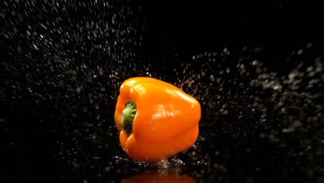 Paprika-Fällt-Auf-Wasser-Vor-Schwarzem-Hintergrund-4k