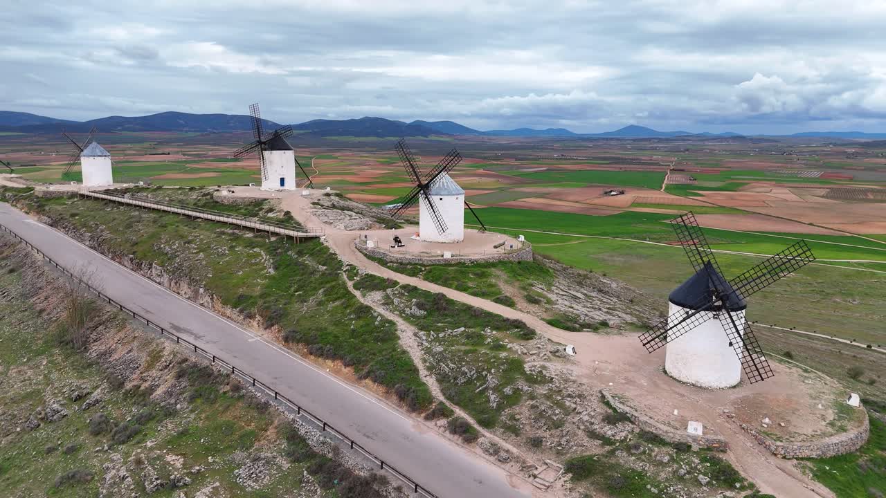 Slow-motion drone view of Consuegra windmills on cloudy day