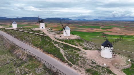slow-motion drone view of consuegra windmills on cloudy day