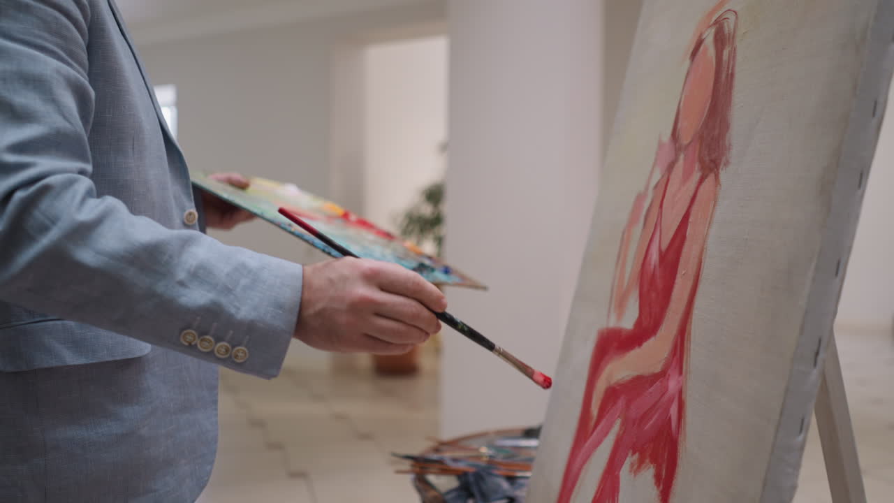 el pintor dibuja a la mujer de los sueños en lienzo en primer plano en el estudio. el artista utiliza la paleta de pinturas acrílicas trabajando en el retrato en el taller. el artesano crea obras de arte coloridas