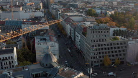 Tilt-down-footage-of-neighbourhood-in-large-town.-Reveal-over-edge-of-roof-view-of-cars-driving-on-streets.-Berlin,-Germany.