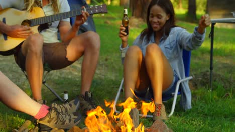 Friends-having-fun-near-bonfire-in-the-forest-4k