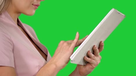 female hands using tablet on a green screen, chroma key