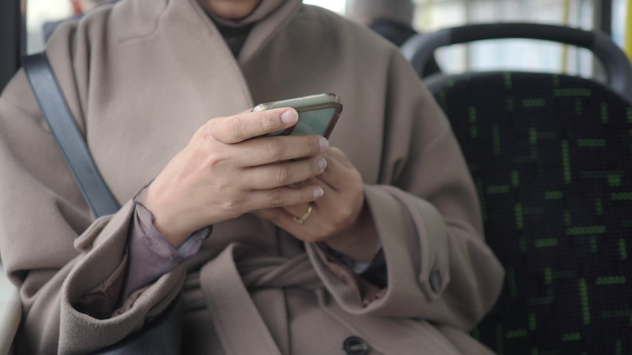 Woman's Hands Using Smartphone on a Bus