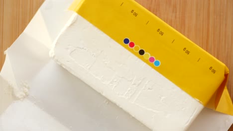 primer plano de un bloque de mantequilla en un envase amarillo
