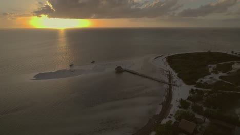 High-angle-drone-shot-as-it-rotates-over-Holbox,-Mexico-at-sunset