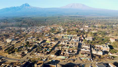 Sonnenaufgang-–-Kenia-Landschaft-Mit-Einem-Dorf,-Kilimandscharo-Und-Amboseli-Nationalpark-–-Verfolgung,-Drohnen-Luftaufnahme