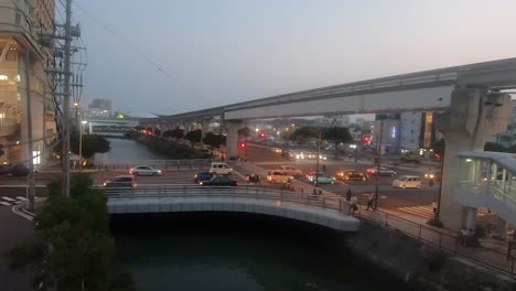 day to night timelapse. naha city intersection in peak hour. trains travel along monorail line.