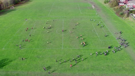 aerial drone video footage of extensive playing fields situated on the summit of a hill