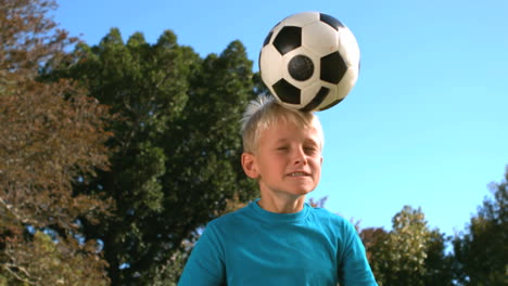 young boy heading a football