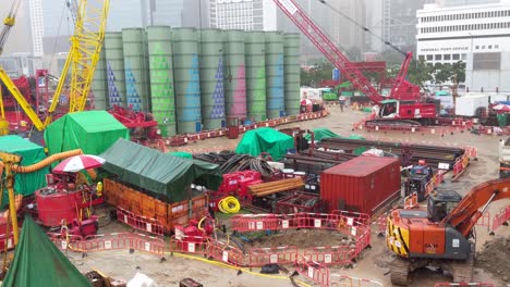 Establishing-shot,-foundation-construction-site-with-bentonite-silos-during-rainstorm