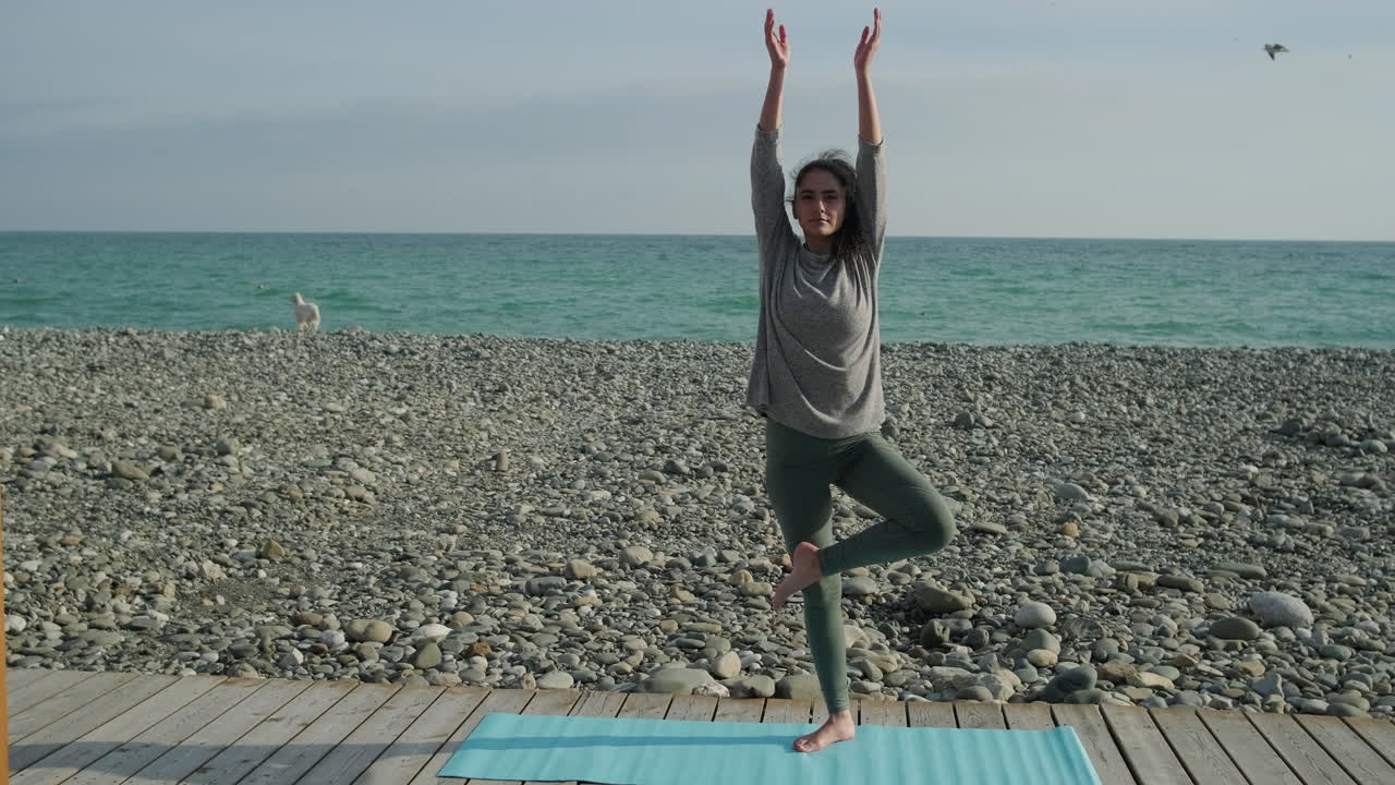 해변에서 요가를 연습하는 여자