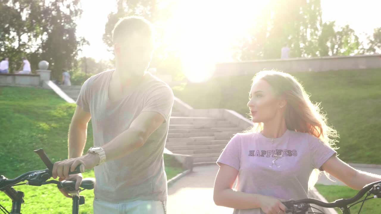 пара едет на велосипеде в парке