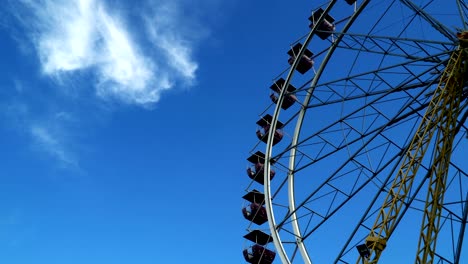 la rueda de la ferris girando contra el cielo con nubes