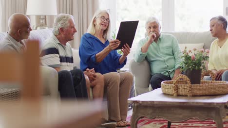 Terapeuta-Caucásica-Senior-Tomando-Notas,-Hablando-Con-Diversos-Amigos-Mayores,-Cámara-Lenta