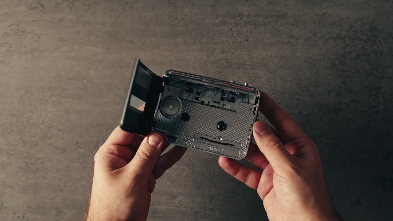 reproductor de cintas de cassette abierto en las manos