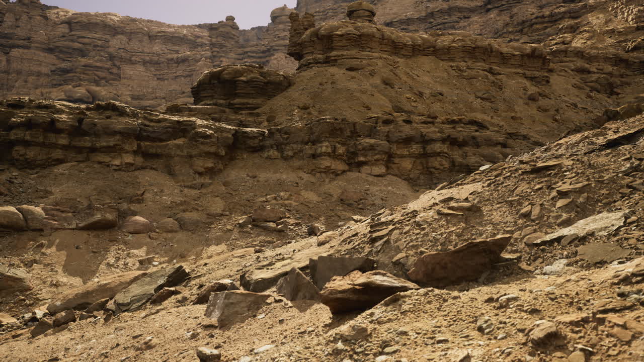 Desert landscape with rocky formations under a clear sky at midday