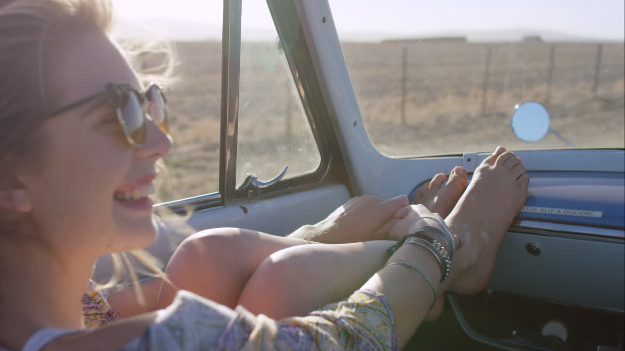 schöne blonde freundin genießt einen roadtrip in einem alten cabriolet