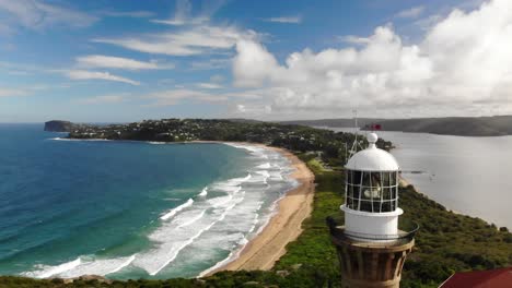 Drohnenansicht-Des-Leuchtturms-Von-Palm-Beach,-Atemberaubende-Nahaufnahme-Von-Palm-Beach,-Australien-Mit-Seiner-Panoramaküste,-Kristallklarem-Wasser-Und-Dem-Ikonischen-Leuchtturm