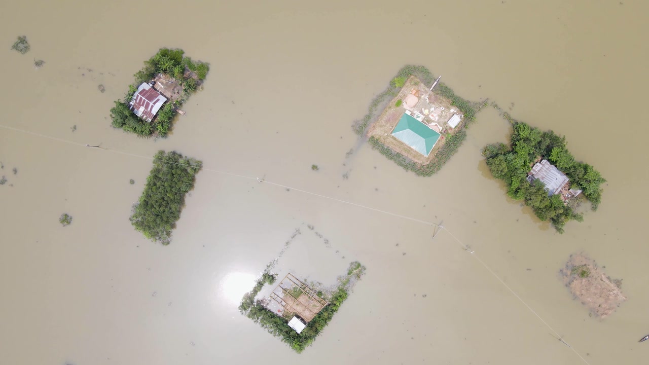 Aerial: Village homes submerged by floodwater due to climate change - top down view.
