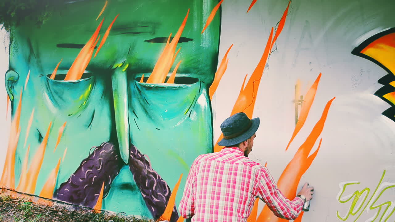 L'artista disegna graffiti su una recinzione. Graffiti su una recinzione.