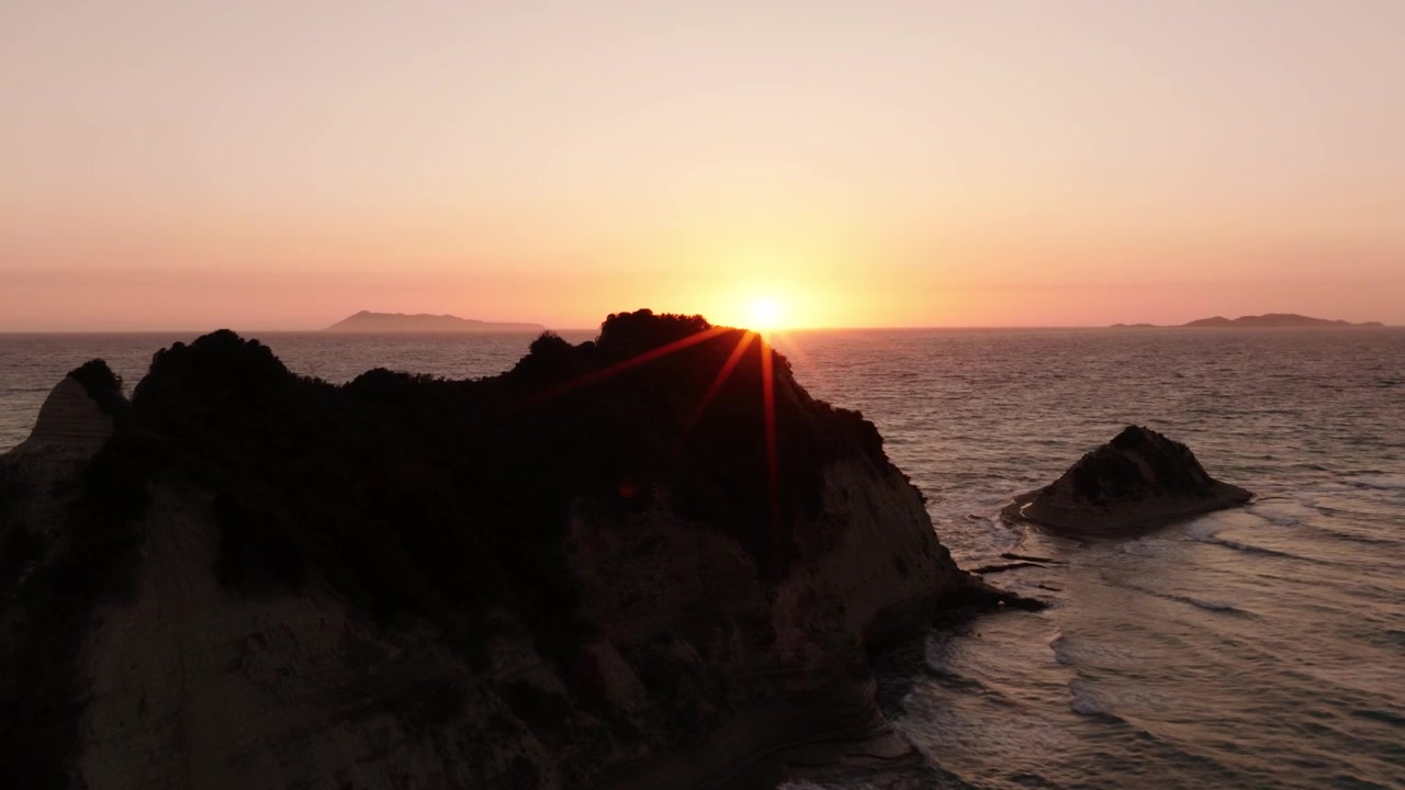 Vista de dron de los farallones de Cabo Drastis brillando al atardecer en Corfú