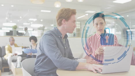 two coworkers collaborating at round wooden table, displaying data security interface overlay