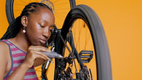 Technician-using-glue-to-repair-broken-bicycle-chain,-studio-background