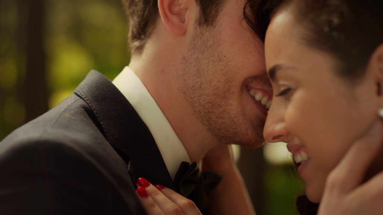Joyful couple laughing outdoors. Bride and groom talking on wedding ceremony