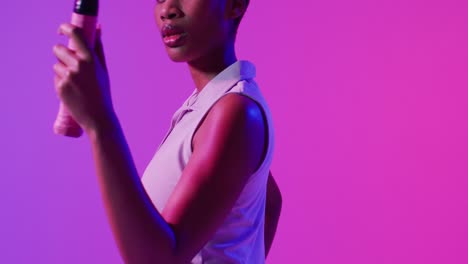 video de la sección media de la tenista afroamericana con raqueta en relámpago rosa de neón