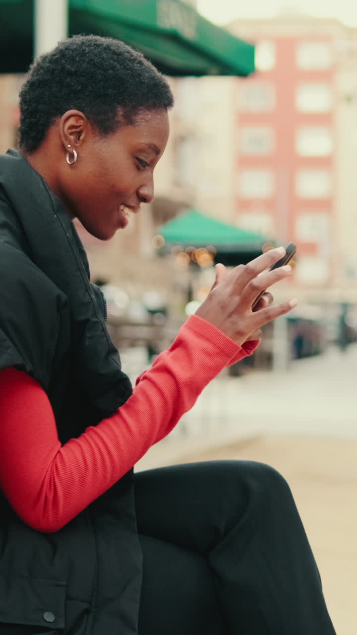 Young African American Woman Smiling and Using Smartphone Outdoors