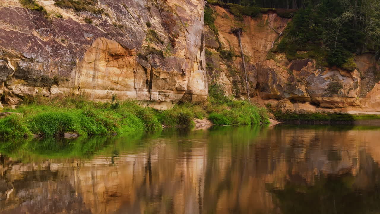 Erglu Cliffs (Eagle Cliffs) In Latvia. Colorful Limestone Rock Formations Dating Back To The Devonian Period. Low Aerial Reverse Reflection Shot Over The Ancient And Timeless Gauja River.