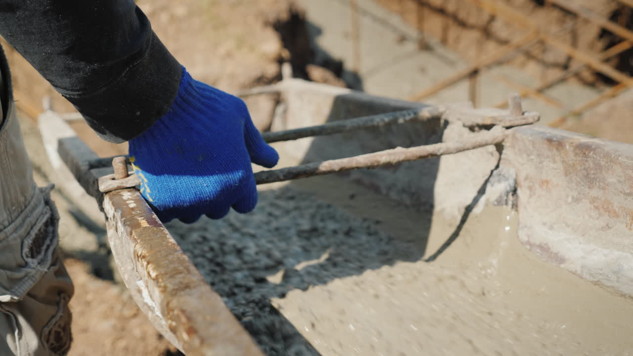 작업자가 콘크리트가 흐르는 낙하산을 지시하는 기초를 붓는 작업
