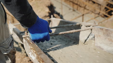 Trabajar-En-Verter-La-Base,-El-Trabajador-Dirige-El-Conducto-Desde-El-Cual-Fluye-El-Concreto