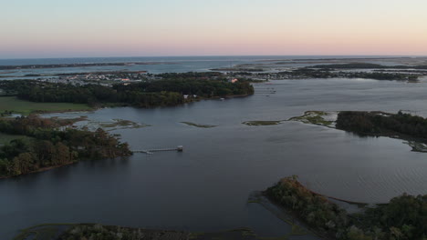 Drone-shot-small-coastal-town-with-salt-marsh-or-wetlands-in-the-foreground,-north-carolina