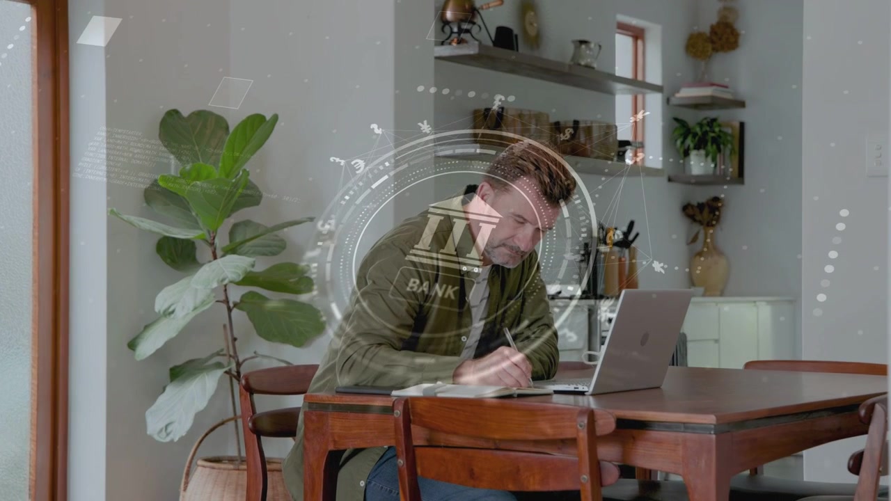 Homme mûr tapant sur un ordinateur portable, initiant une incrustation bancaire, prenant des notes, vérifiant son téléphone, gérant ses finances