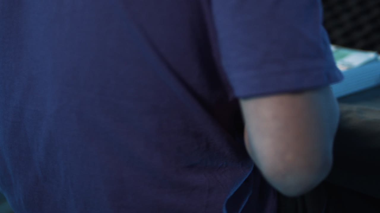 un hombre maduro con camiseta nos pone dólares y otras monedas en una maleta metálica.