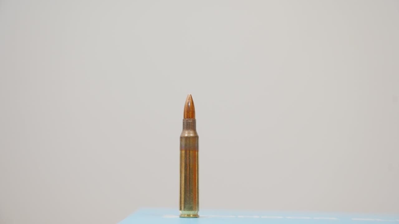 un hombre preparando rondas de rifle en una línea dentada