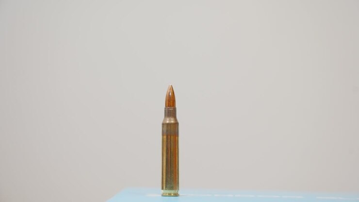 A man setting up rifle rounds in a jagged line
