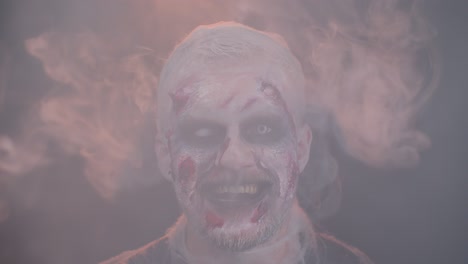 Zombie-man-with-makeup-with-wounds-scars-and-white-contact-lenses-blows-smoke-from-nose-and-mouth