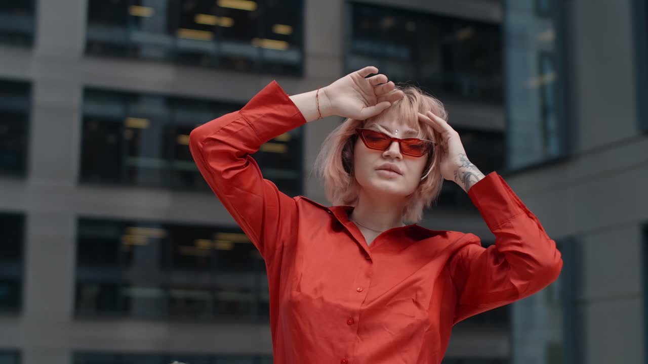 Stylish Woman in Red Shirt and Sunglasses in a City